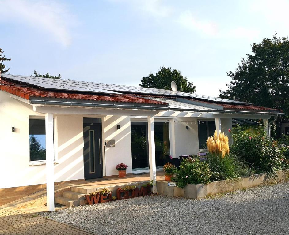 a small white house with a porch and some plants at Auszeit Erfurt - stilvoller Bungalow mit Parkplatz - zentrumsnah in Erfurt