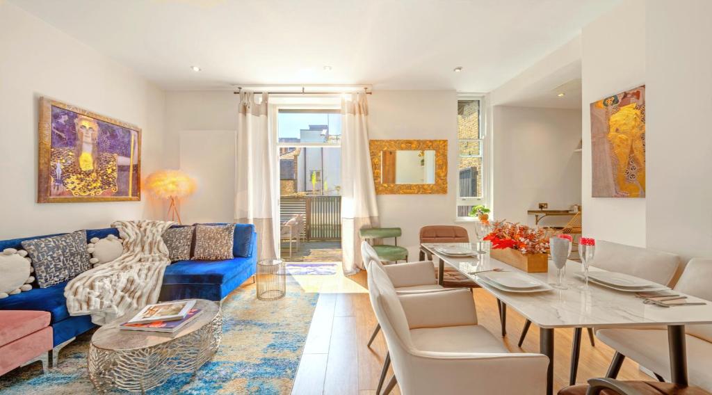 a living room with a blue couch and a table at DESIGNER Victorian Flat with HUGE Terrace in London