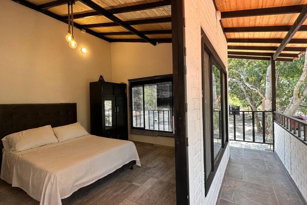 a bedroom with a bed and a balcony at Moderna casa campestre in Guamo