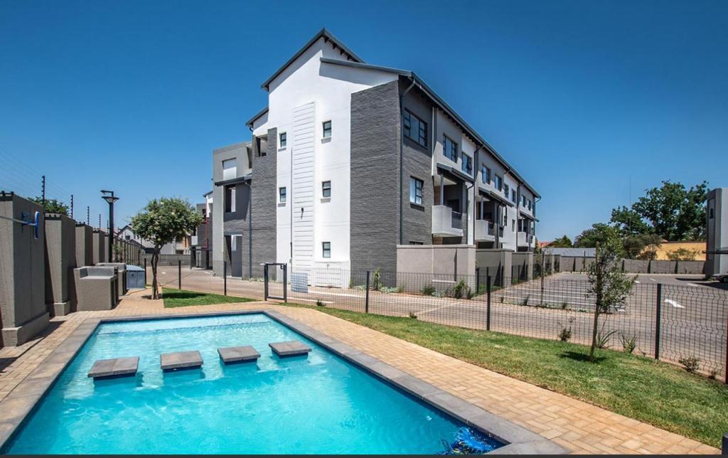a swimming pool in front of a building at Mya Villa 2 in Fourways