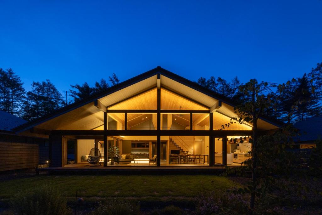 a house with large glass windows at night at Villa Metsä KARUIZAWA in Karuizawa