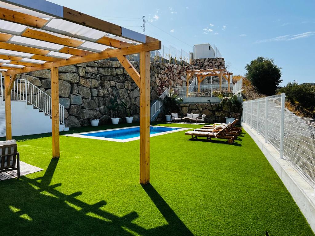 a backyard with a fence and a grass yard at Villa Axarquia paraiso 88 Sinese Design Homes in Viñuela