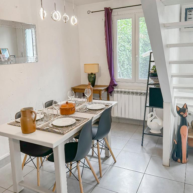 une table à manger blanche avec des chaises et une salle à manger dans l'établissement Détente à la Plage à Les Mathes, aux Mathes