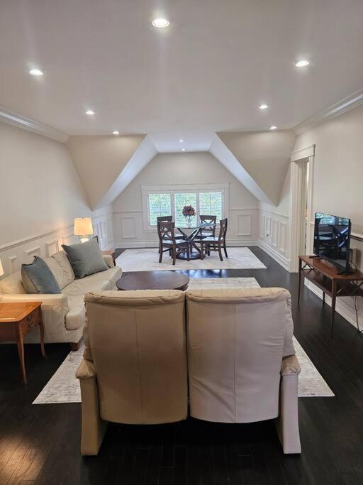 a living room with a couch and a table at IODE Clark House Top Floor Apartment in Fredericton
