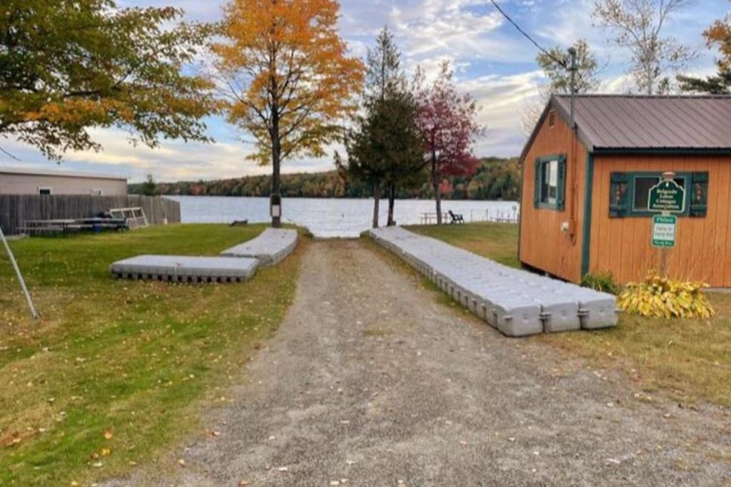 a small house with a path next to a body of water at Cozy Cove Cottage Winter Rental Available in Belgrade