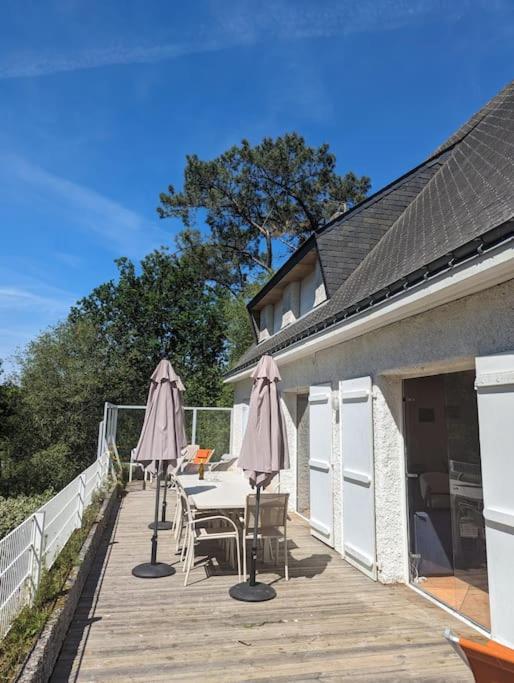 - une terrasse avec 2 parasols, une table et des chaises dans l'établissement Mané Roz, au Bono