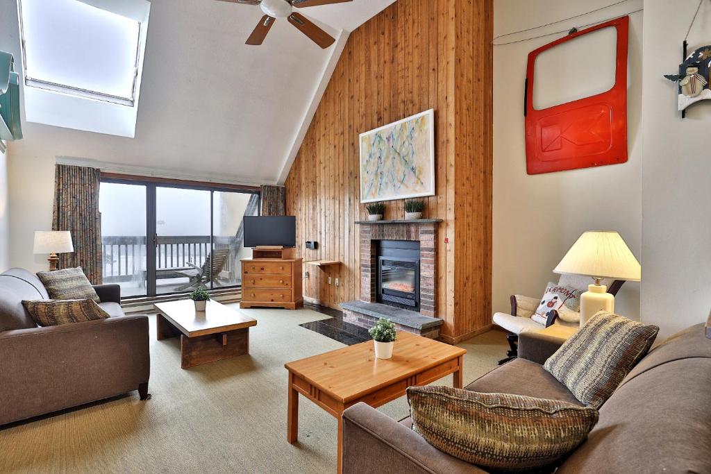 een woonkamer met banken en een open haard bij Loft, Top-Floor Mountain View 2BR-2BA at Mountain Green, Pool, Hot Tub, Shuttle in Killington