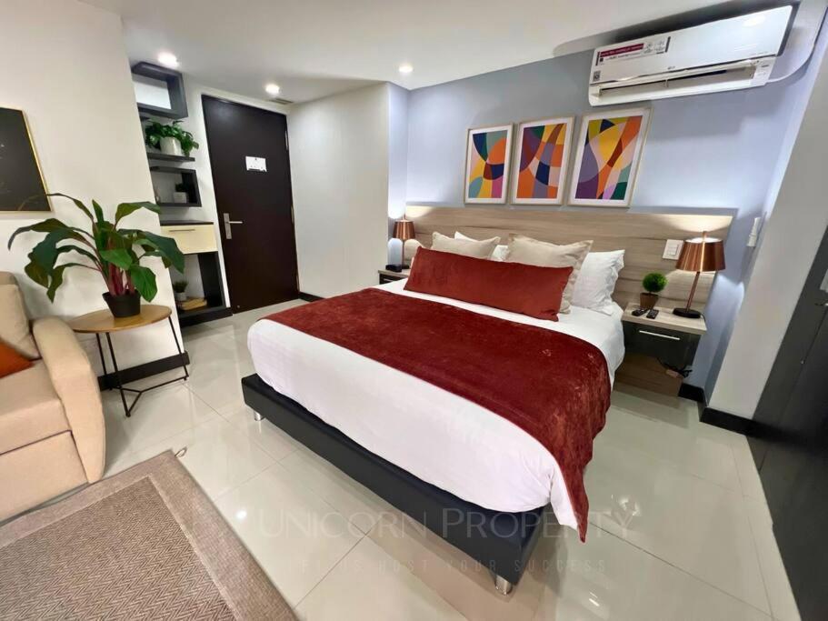 a bedroom with a large bed with a red blanket at Luxury Studio in El Poblado Modern Charm in Envigado