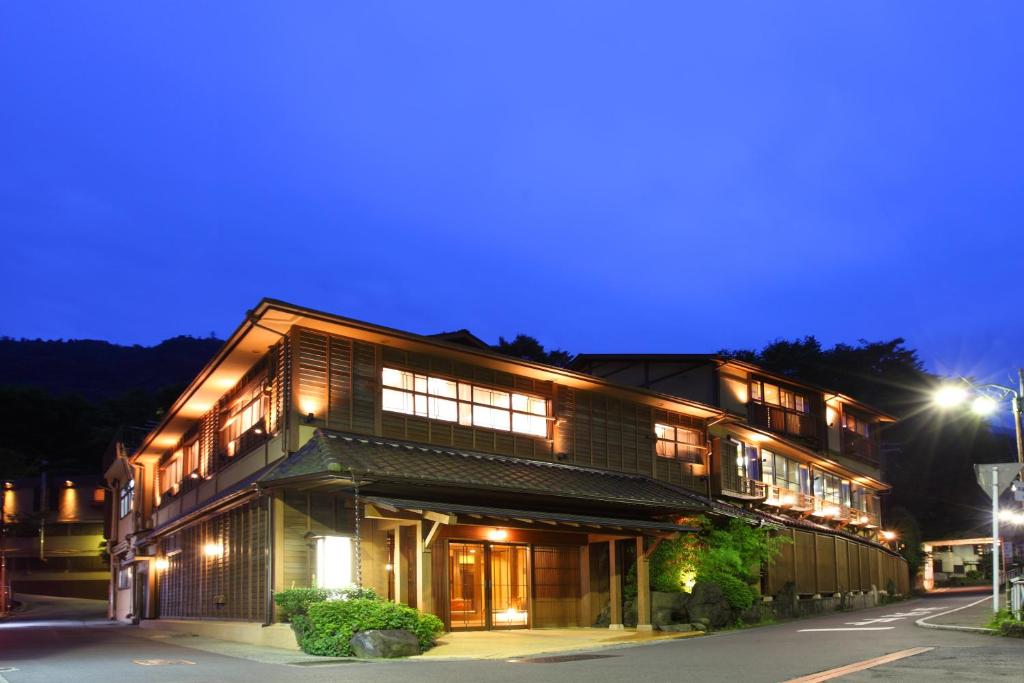 ein großes Holzgebäude mit Nachtbeleuchtung in der Unterkunft Hakone Onsen Ryokan Yaeikan in Hakone