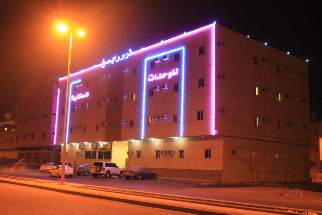 un edificio con luces púrpuras en el lateral. en Dorar Rabigh Complex Residential Units, en Rabigh