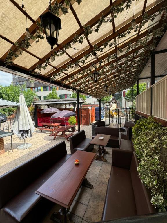 un patio con tavolo e panche in legno di Bridge Park Hotel a Londra