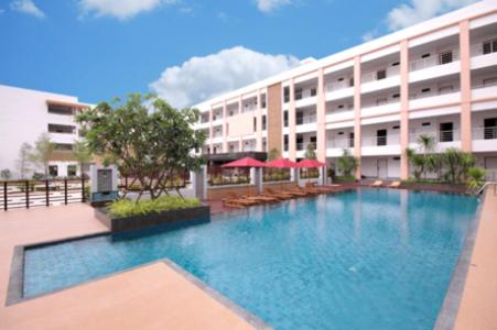 a large swimming pool in front of a building at Paragon Suites Resort in Jomtien Beach