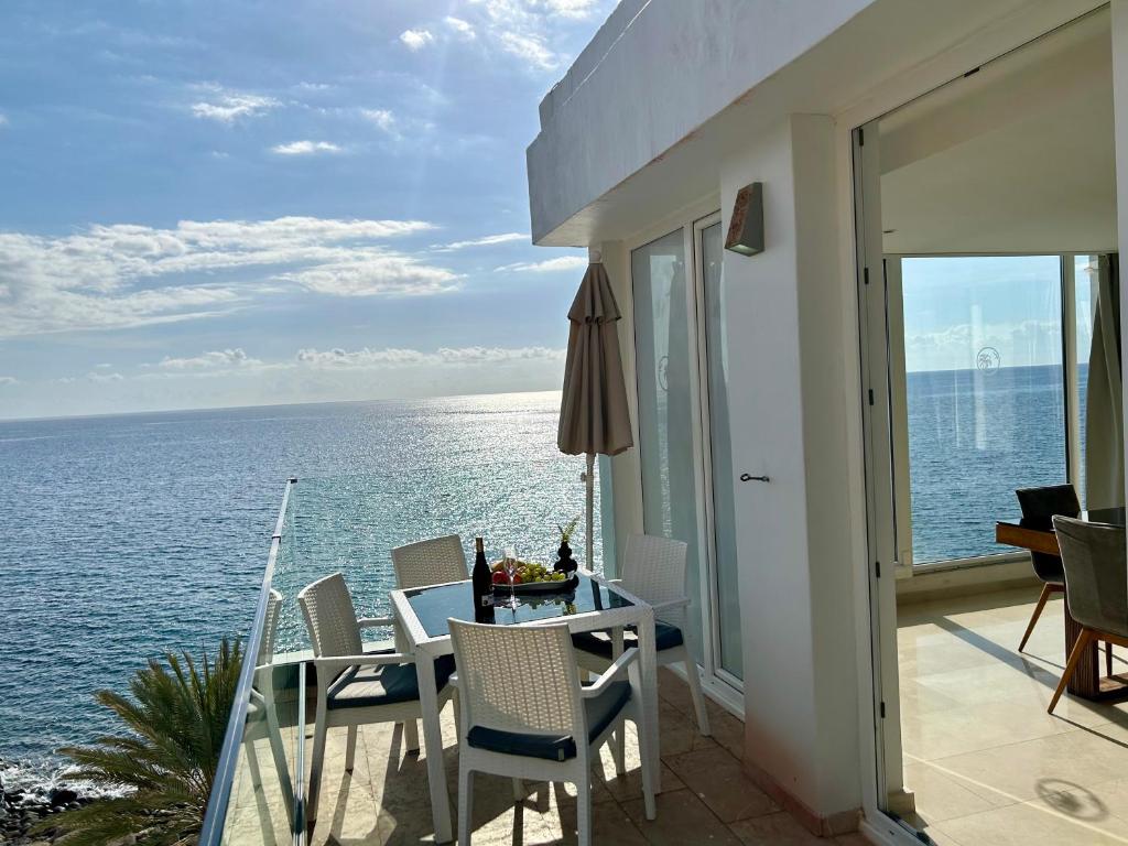 a balcony with a table and chairs and the ocean at Sunset Ocean Beach Point Oceanvrent in Arguineguín