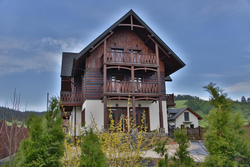 ein großes Holzhaus mit Balkon in der Unterkunft Pensjonat Spiski in Kacwin