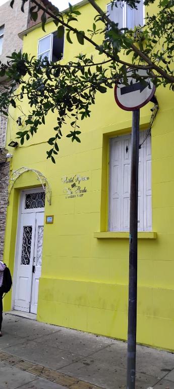 a yellow building with a white door on a street at Hostel Aprisco São Paulo in São Paulo