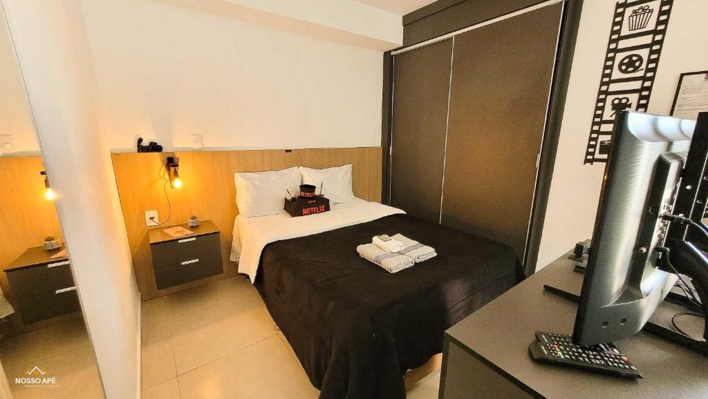 une chambre d'hôtel avec un lit et un bureau avec un ordinateur dans l'établissement Nosso Apê 915: Piscina | TV Box | Academia - NA2002, à Juiz de Fora