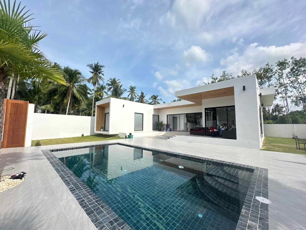 a swimming pool in front of a house at Pisingha Pool Villa Khanom in Khanom