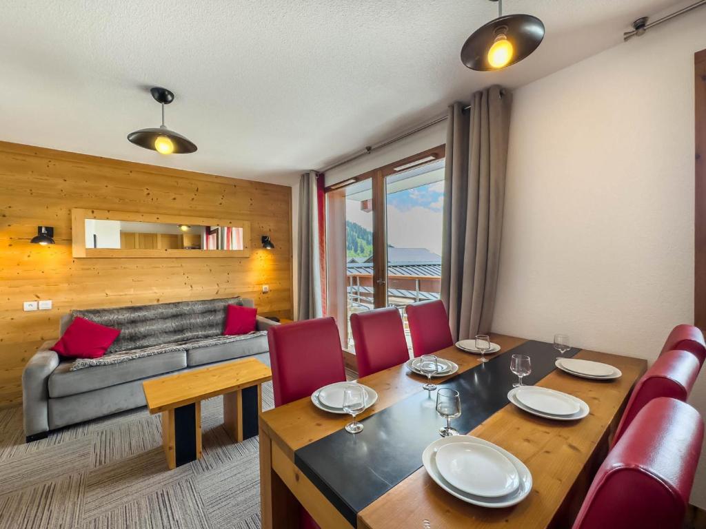 une salle à manger avec une table, des chaises et un canapé dans l'établissement Appartement avec Piscine, Sauna et Terrasse aux Saisies - FR-1-809-1, aux Saisies