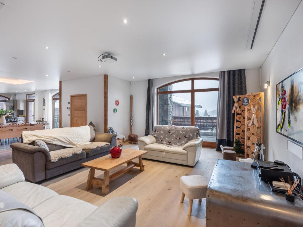 un salon avec des canapés et une table dans l'établissement Loft spacieux avec spa, piscine, salle de sport et parking - FR-1-809-4, aux Saisies