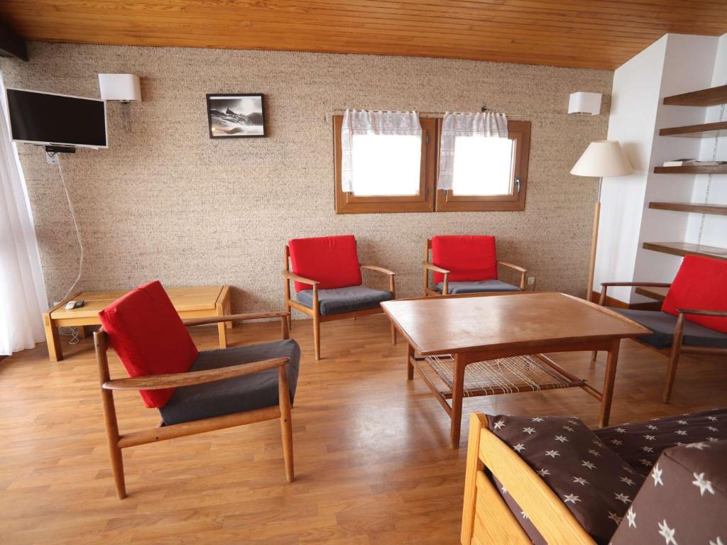 - un salon avec des chaises rouges et bleues et une table dans l'établissement Spacieux duplex 3 pièces mezzanine à 250m des pistes avec parking, animaux admis - FR-1-297-340, à Auris
