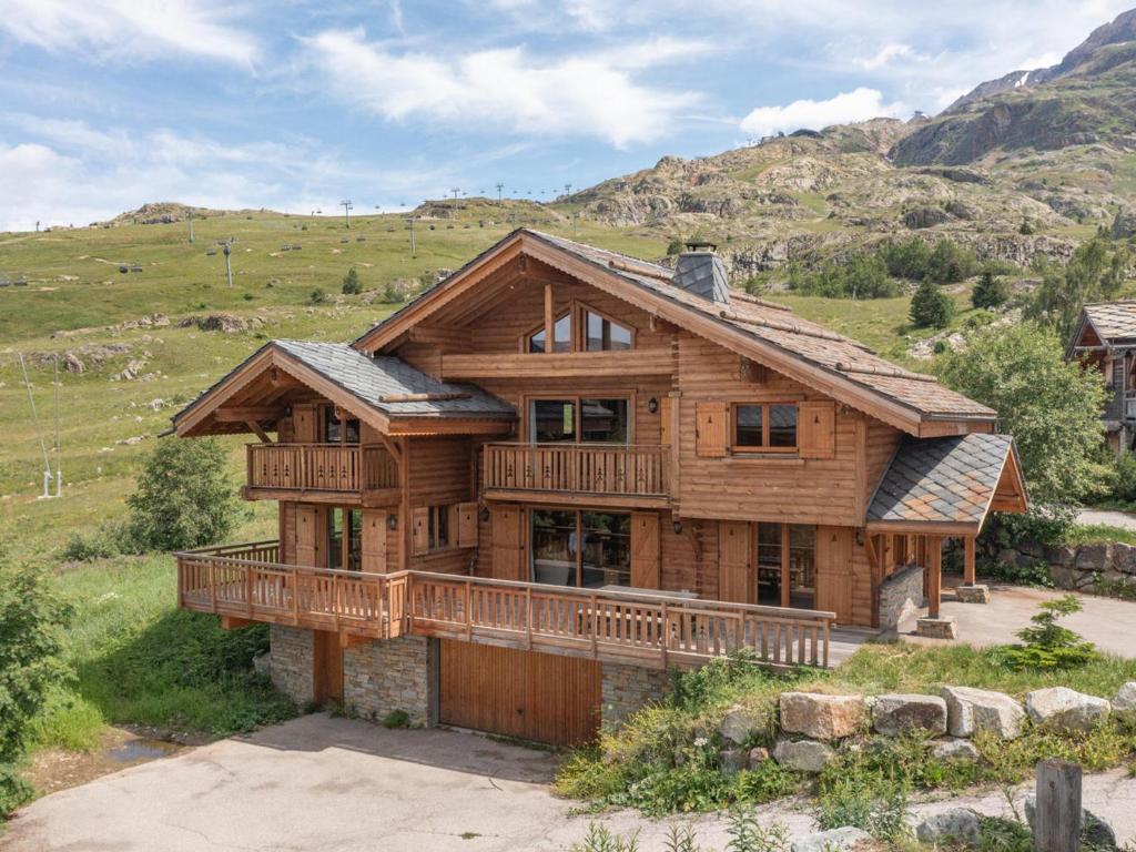 a large wooden house with a balcony on a hill at Chalet de luxe 178m2, aux pieds des pistes avec hammam et salle de jeux - FR-1-645-77 in LʼHuez