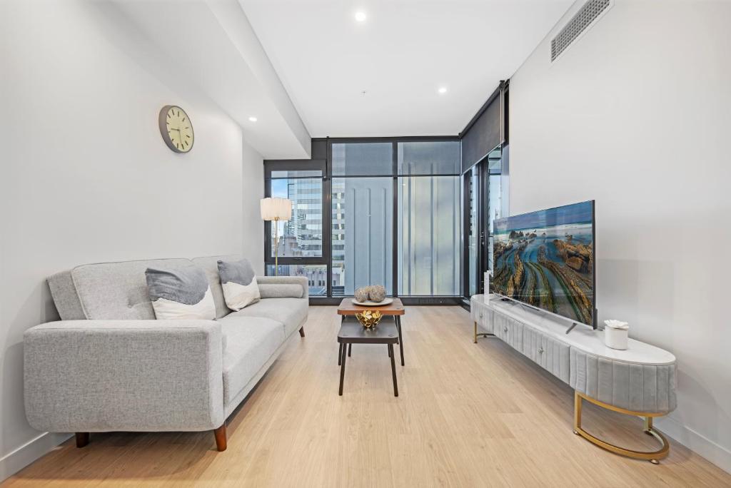 シドニーにあるCBD Center Gem Modern 1-Bedroom Aptのソファとテーブルのあるリビングルーム