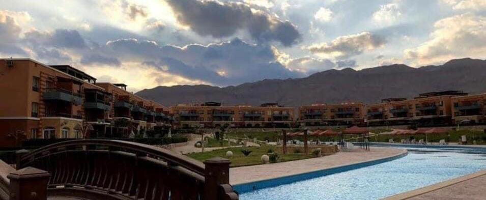 a view of a resort with buildings and a river at Blumar El sokhna in Al Ḩafāʼir