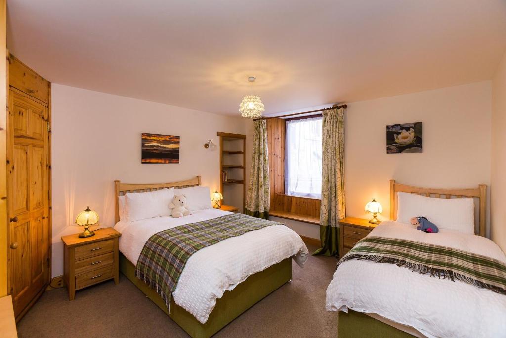 een slaapkamer met 2 bedden en een raam bij Corbie Self Catering Shetland in Lerwick