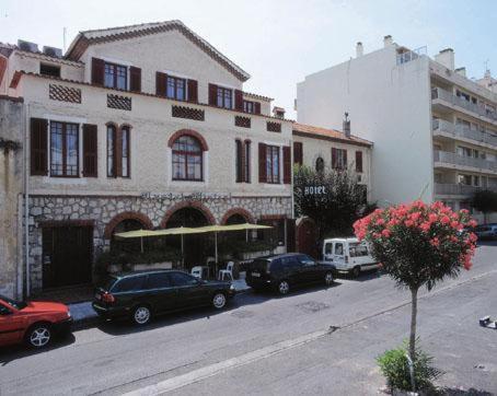 un grupo de coches estacionados frente a un edificio en Hôtel Castel Mistral, en Juan-les-Pins