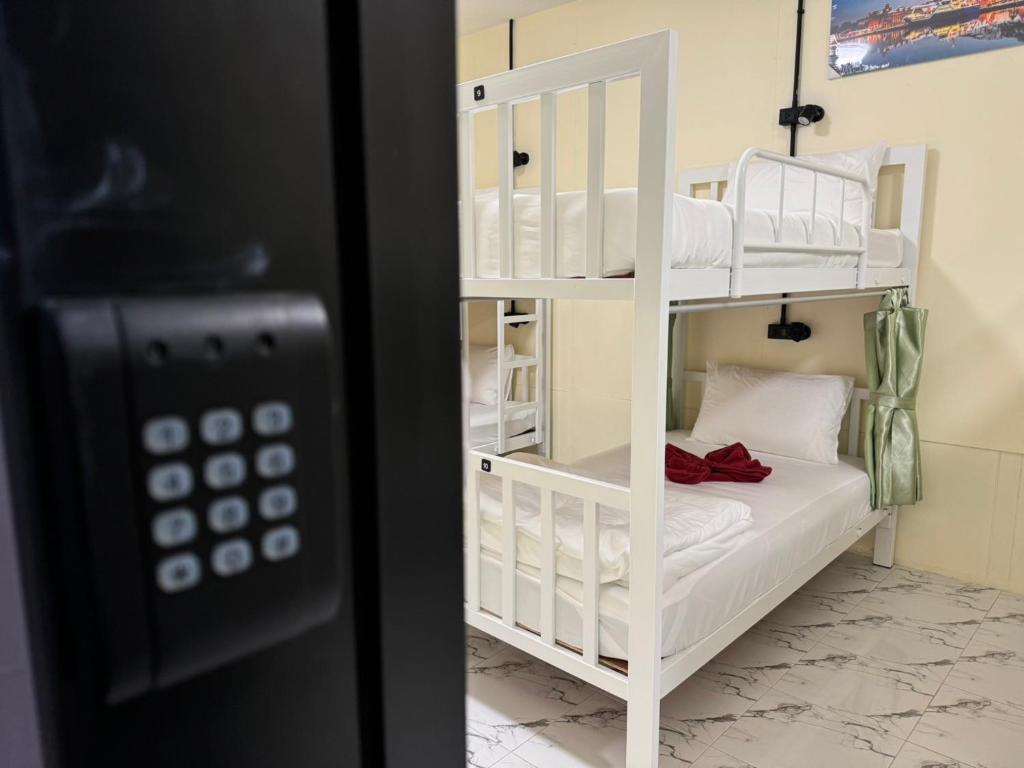 カオソックにあるBunk Bed Hostel Khao Sokの電話のある部屋に白い二段ベッドがある