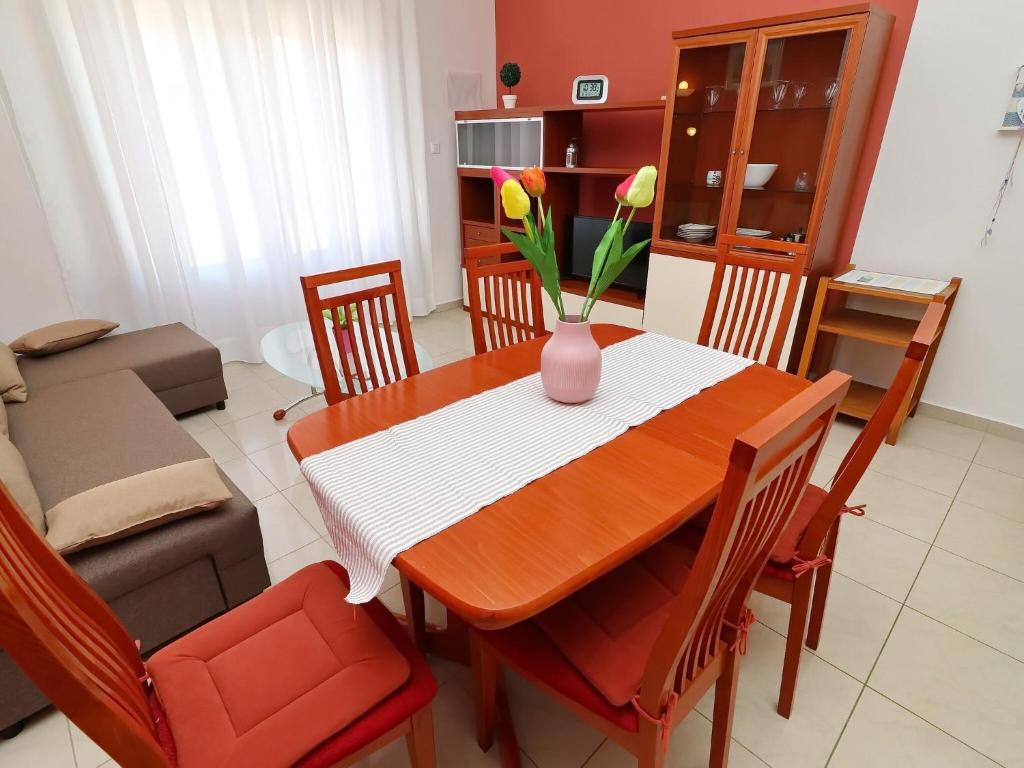 a dining room table with a vase of flowers on it at Apartments K & N -One Bedroom Apartment in Prizba