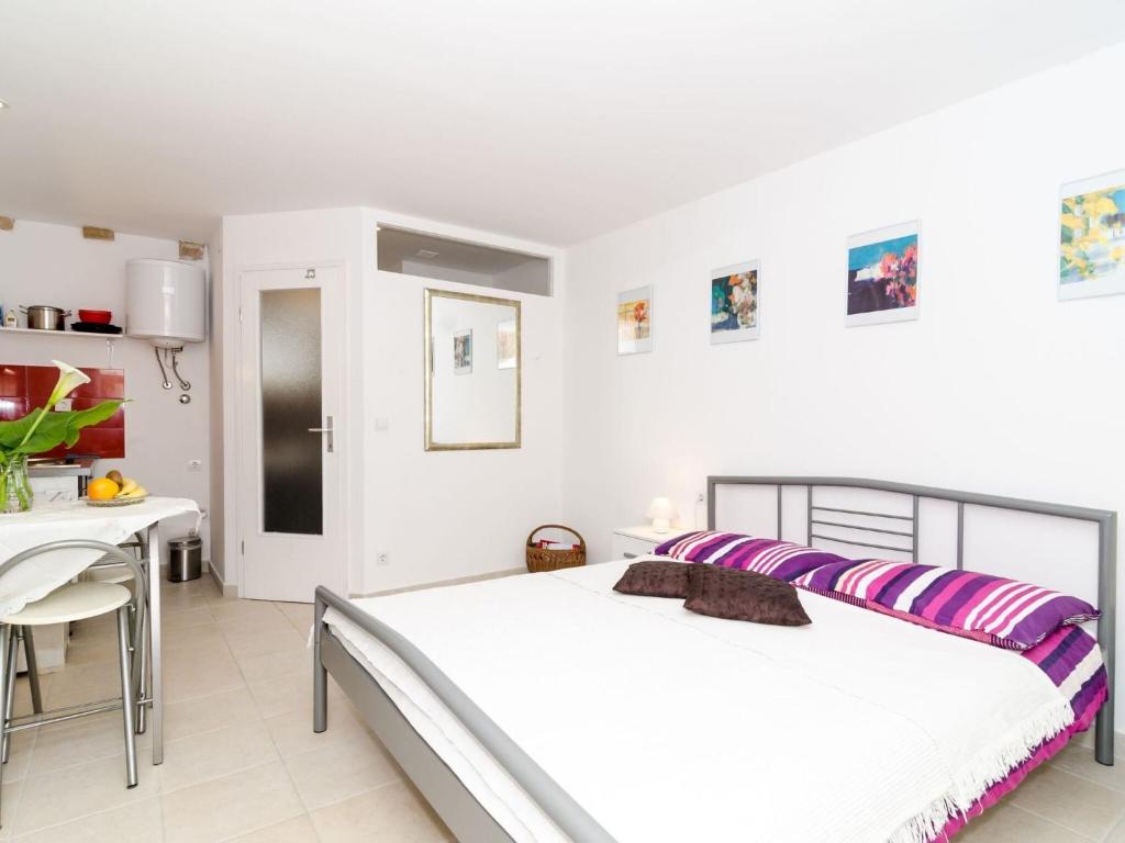 Un dormitorio blanco con una cama y una mesa. en Apartment Lee Loo - Studio Apartment, en Dubrovnik