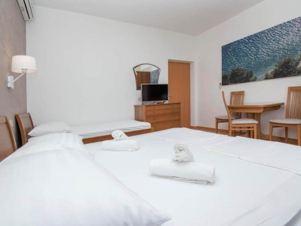 une chambre avec un lit blanc et une table dans l'établissement Apartments Antonio - Studio with Balcony 2, à Tučepi