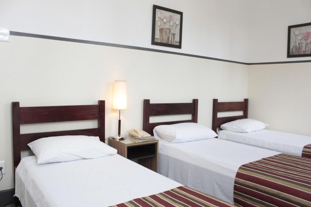 a hotel room with two beds and a telephone at Sul América Palace Hotel in Belo Horizonte