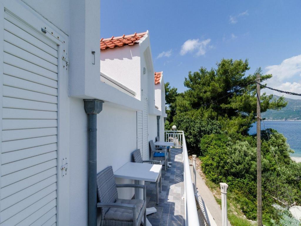 einen Balkon mit einem Tisch und Stühlen mit Blick auf das Wasser in der Unterkunft Holiday Home Ma us-One Bedroom Apartment with Balcony in Koločep