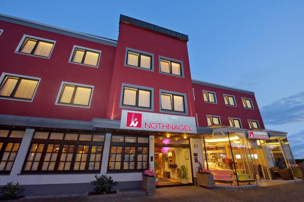 un edificio rojo con una tienda delante en Hotel Café Nothnagel, en Griesheim