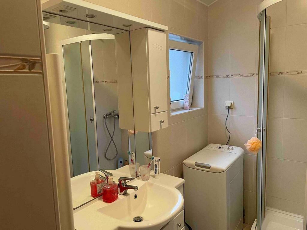 une salle de bains avec lavabo, toilettes et miroir dans l'établissement Apartment Luka - One Bedroom Apartment with Balcony and Sea View, à Šibenik