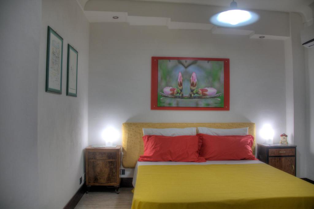 a bedroom with a yellow bed and two night stands at Sogniblei Locazione Turistica in Ragusa
