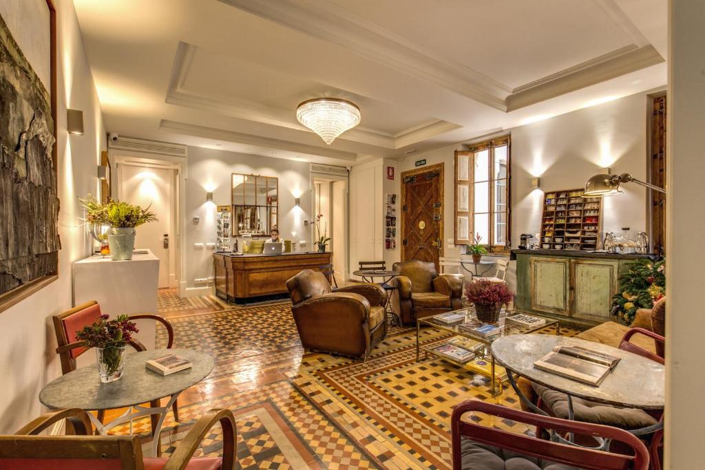 a living room with couches and tables and chairs at We Boutique Hotel Barcelona in Barcelona