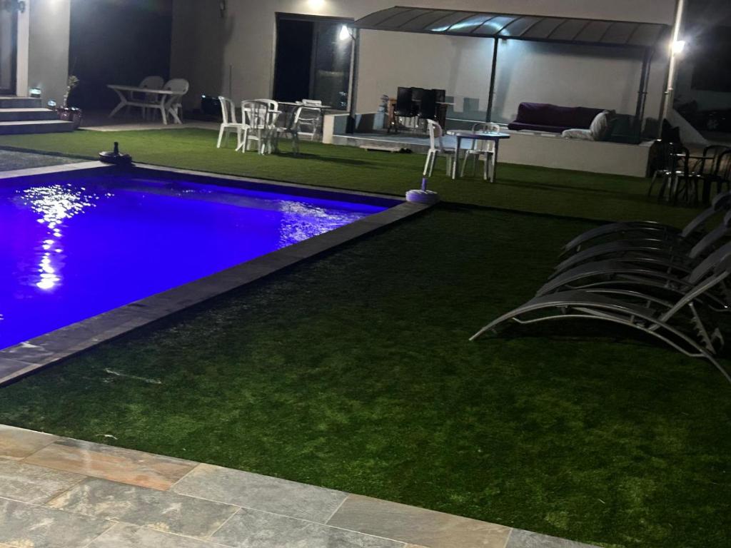 - une piscine avec de l'herbe artificielle, une table et des chaises dans l'établissement grande villa avec piscine, à Bompas