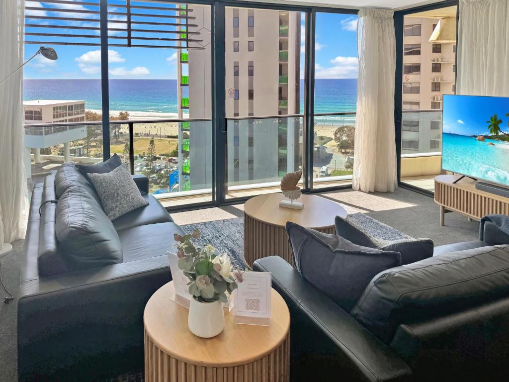 a living room with a couch and a television with a view of the ocean at Oracle 11th floor Tower 1 - GC Getaways in Gold Coast