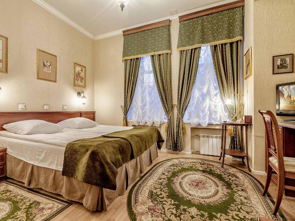 a bedroom with a large bed and two windows at Silver Age in Saint Petersburg