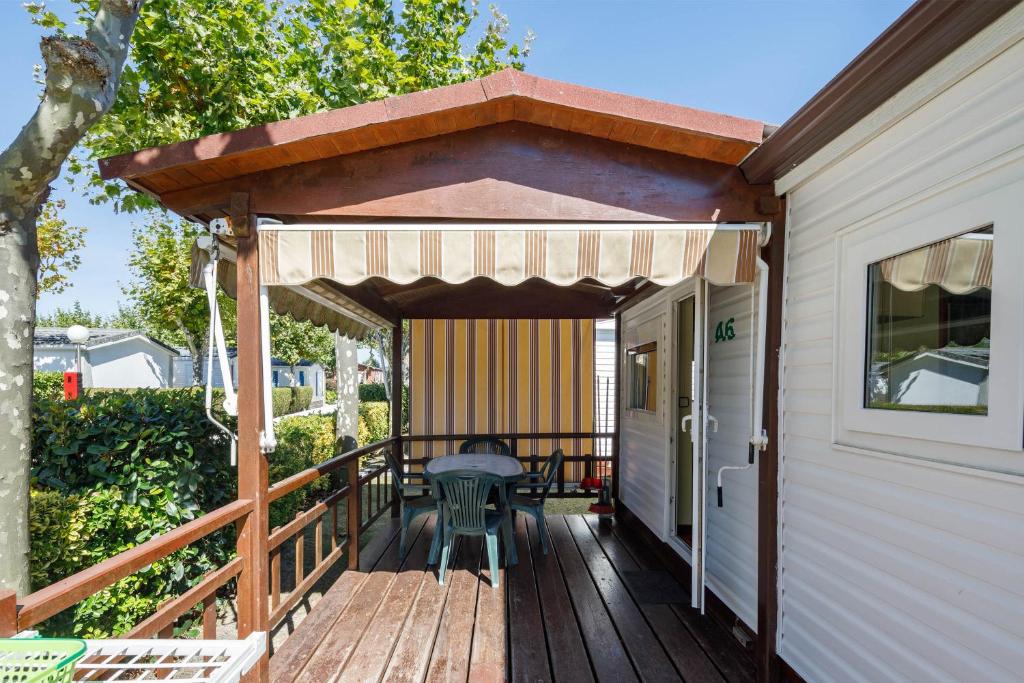 Una terraza de madera con toldo en una casa en Bungalow A, en Pontevedra