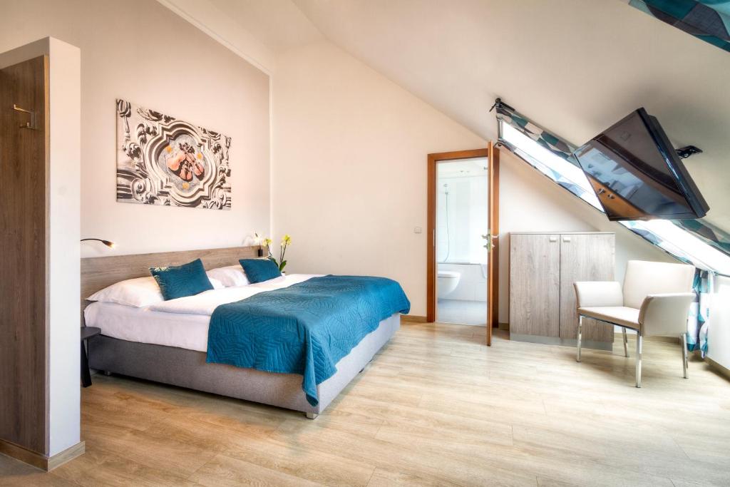 a bedroom with a large bed and a bathroom at Hotel Páv in Prague
