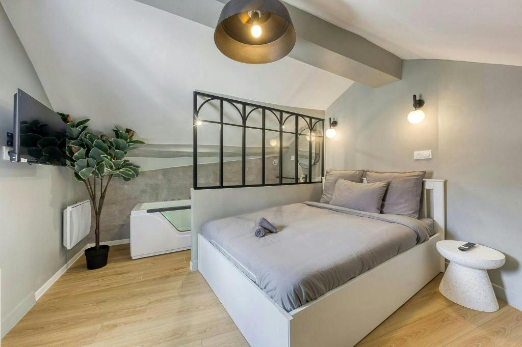 a bedroom with a bed and a potted plant at The Duplex spa Paris in Bagnolet