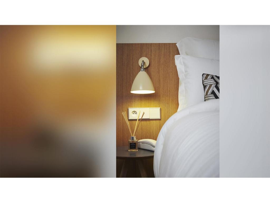 a bedroom with a bed with a lamp and a phone at 9Hotel Republique in Paris