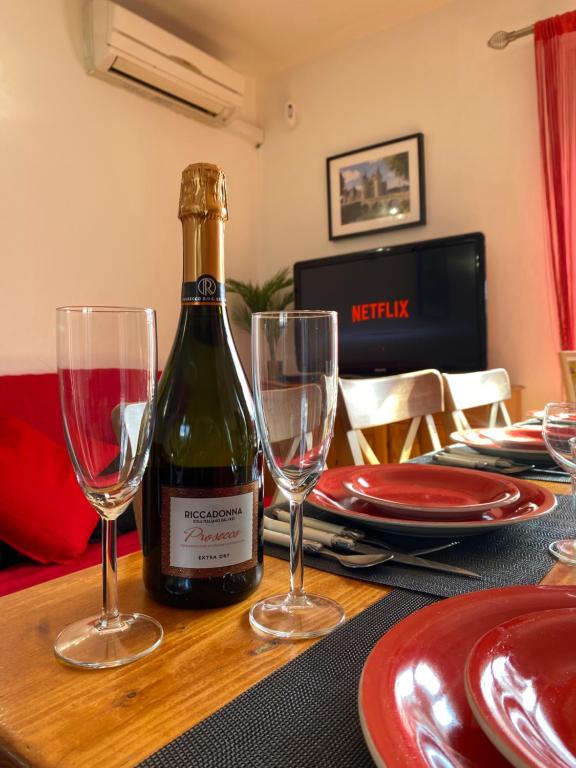 eine Flasche Wein auf einem Tisch mit zwei Weingläsern in der Unterkunft L'Escapade, Proche Carré-Sénart et Disneyland in Combs-la-Ville