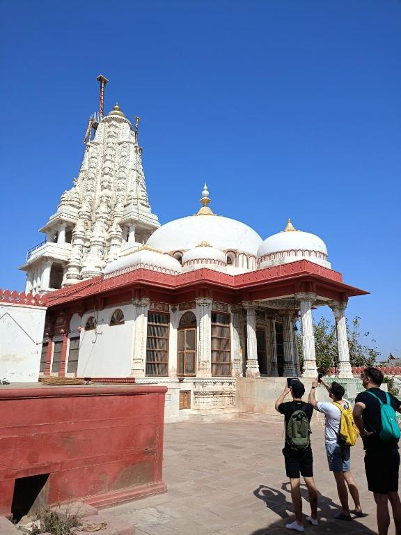 a group of people taking pictures of a temple at Rose Merry Guesthouse in Bikaner