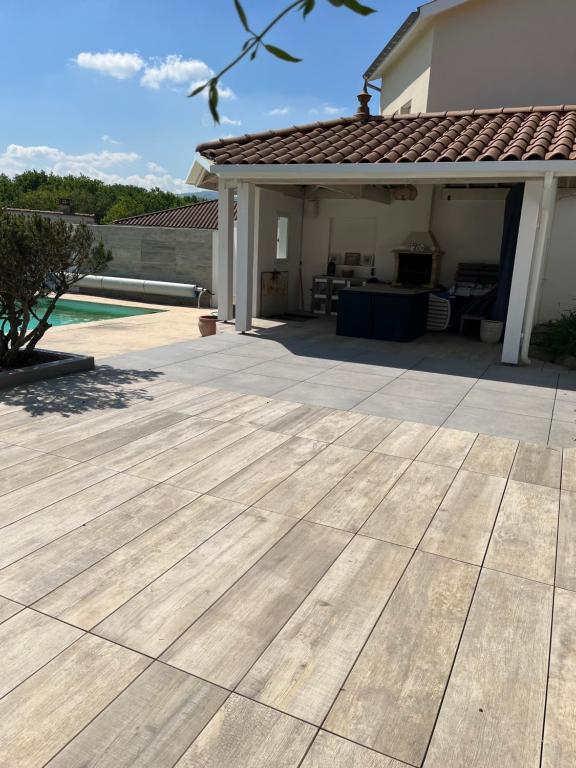 une terrasse en face d'une maison dans l'établissement Maison 4p, vue Monts du lyonnais, à Grézieu-la-Varenne