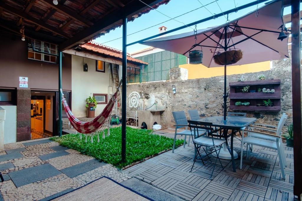 a patio with a hammock and a table and chairs at GuestReady - Peaceful haven in Funchal in Funchal